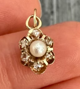 Vintage Diamond and Pearl Flower Charm (S): Flat-back disc pendant with a satin finish background, featuring a stylized layered flower motif set with a round white diamond center and 5 surrounding white seed pearl petals. Diameter: 16 mm.