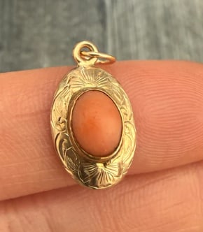 Vintage Natural Pink Coral and 14k Gold Chased Charm (S): Organic barrel charm featuring a smooth, hand-carved piece of pastel pink natural Mediterranean coral capped on both ends with hand-engraved/chased floral leaf 14K borders. Measures 14 mm long x 8 mm 