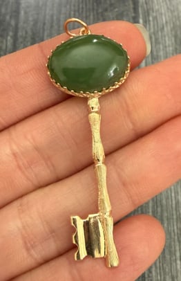 Vintage Jade and 14K Gold Bamboo Style Key Pendant: Large retro openwork skeleton key pendant constructed around a thick, rich spinach-green natural nephrite jade round stem bar, capped with a detailed gold handle and teeth mimicking natural bamboo sho