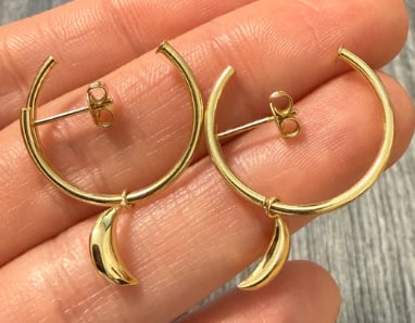 Celestial 14K Gold Hoop Earrings with Dangling Crescent Moon Charm: Whimsical modern post hoop huggies in 14K yellow gold, featuring a dangling, high-polish stylized crescent moon profile charm swaying from the bottom curve of each loop. Total drop: 25 mm; hoop thickn