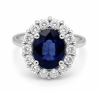 18k Sapphire Ring: Prestigious cocktail statement ring centering a massive, deep royal blue oval-cut natural sapphire (approx 3.80 cts) claw-mounted inside a split geometric shoulder frame of 18K white gold laden with