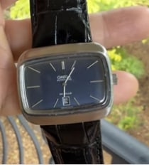 1970's Omega Deville Watch: Vintage retro luxury horology. Mid-century Omega De Ville mechanical dress watch featuring a rare television/cushion-shaped stainless steel case with a minimalist brushed silver dial and original sign