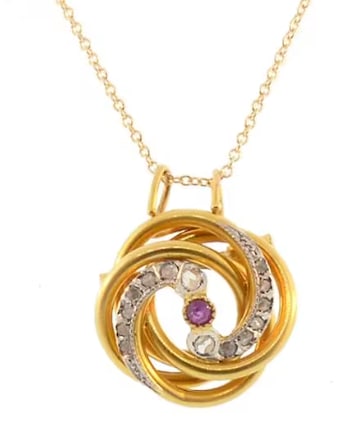Ruby Diamond & 18K Gold French Love Knot Pendant: Elegant classic estate pendant crafted in 18K yellow gold. Modeled as a multi-layered intertwining textured wire love knot, centered cleanly by a bright white gold illusion setting holding a fiery rou