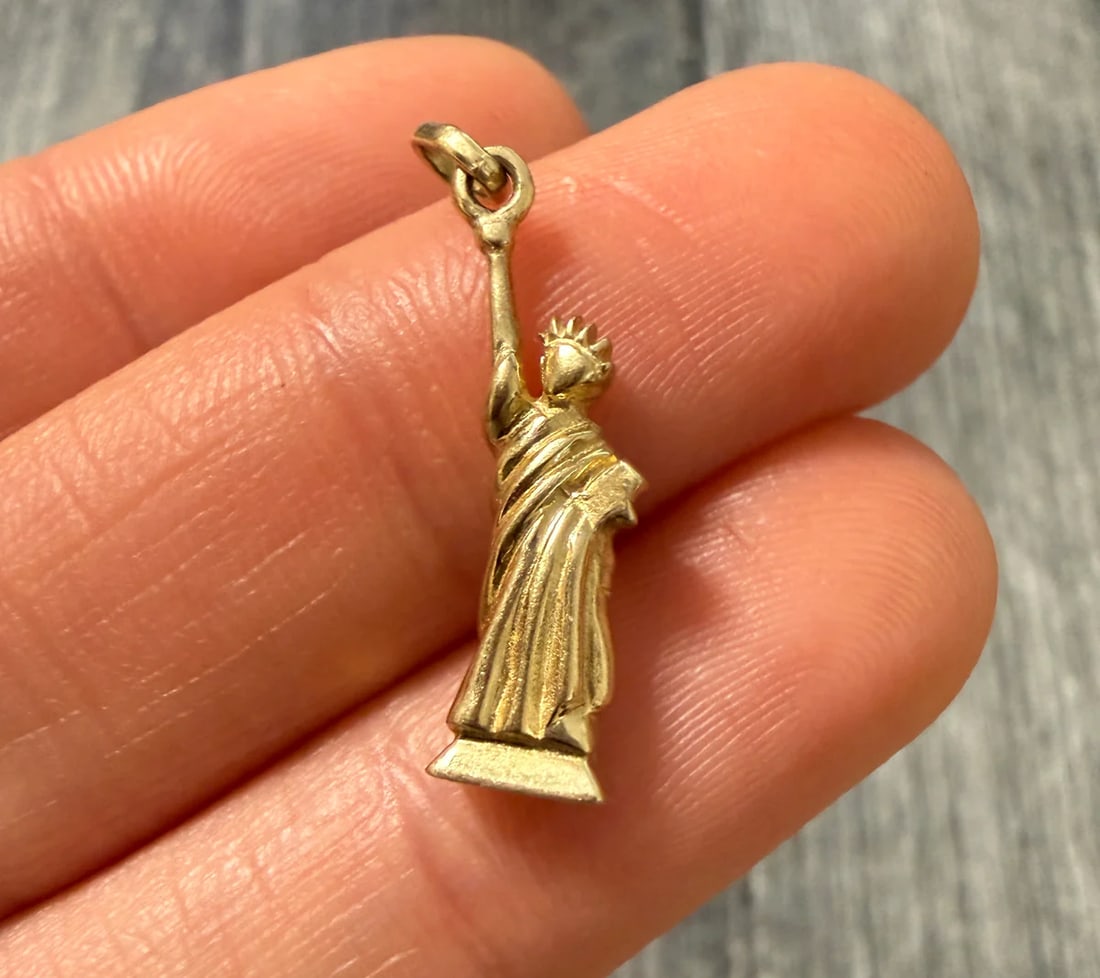 14K Gold NYC Statue of Liberty Charm: Metal: 14K Yellow Gold Weight: 1.8 gramsMeasurements: 0.75 inches long by 0.25 inches wideMarkings: "14K ITALY"Condition: In very good condition with some minor surface wear.