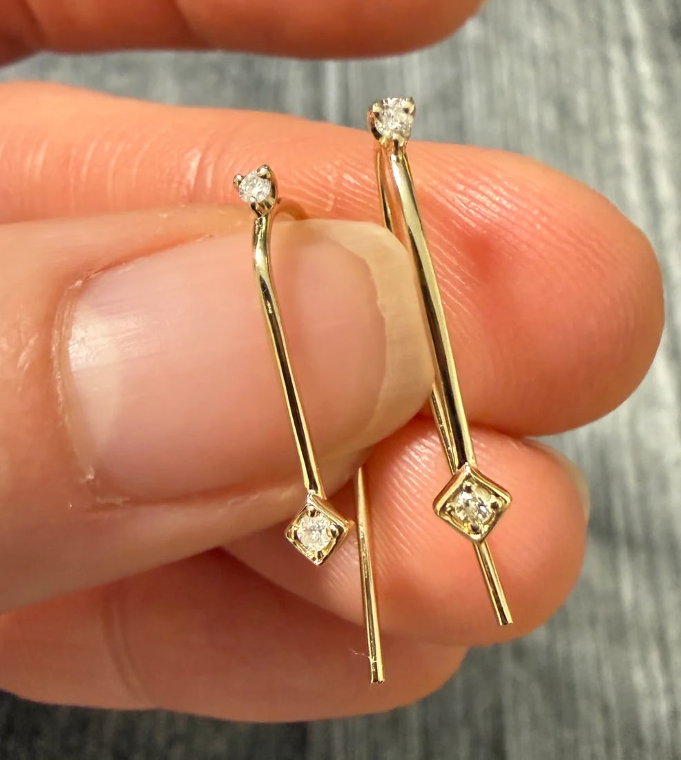 Diamond and 14K Gold Hook Dangle Earrings: Metal: 14K Yellow Gold Weight: 0.8 gramsDiamonds: Approximately 0.07 caratsMeasurements: 0.75 inches longMarkings: "14K"Condition: In very good condition with some minor surface wear.