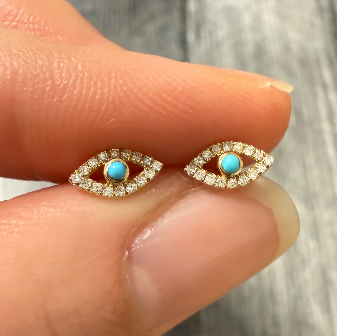 Turquoise and Diamond Evil Eye Stud Earrings: Metal: 14K Yellow Gold Weight: 0.7 gramsDiamonds: Approximately 0.15 caratsMeasurements: 0.2 inches long by 0.3 inches wide Markings: "14K"Condition: In very good condition with some minor surface
