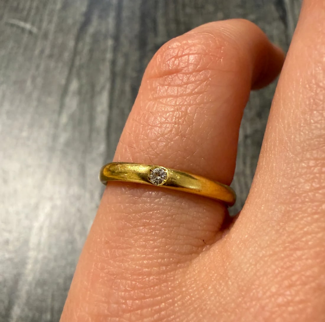 Single Diamond Set 18K Gold Band: Metal: 18K Yellow Gold Weight: 2.6 gramsDiamond: Approximately 0.03 caratsRing Size: 5 (fits like a 5.25)Width: 2.4 mm wide Markings: "750"Condition: In very good vintage condition with some minor