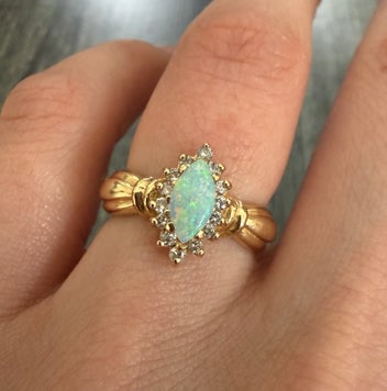 Marquise Opal and Diamond Ring in 14K Gold: A stunning 14K yellow gold ring featuring a central marquise-cut opal with fiery play-of-color and sparkling accent diamonds.
