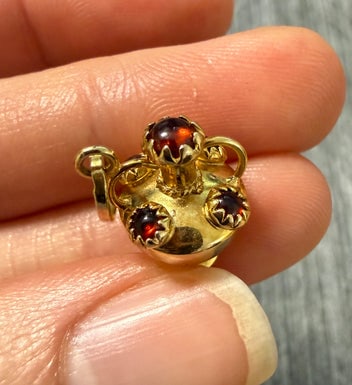 Vintage Garnet and 14K Gold Urn Vase Charm: An ornate Victorian-style urn or vase charm in 14K gold, accented with small round-cut garnets.