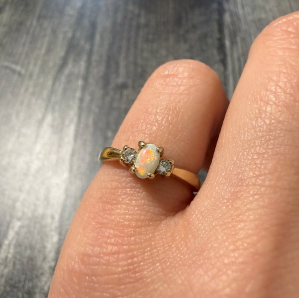 Vintage Opal and Diamond Ring in 14K Gold: A delicate 14K gold band featuring a central opal surrounded by a cluster of small diamonds.