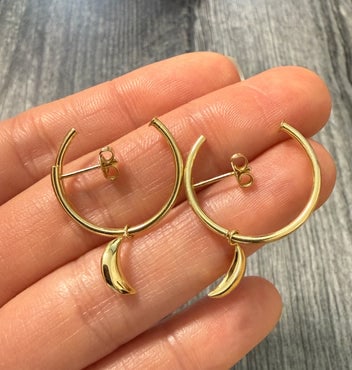 Celestial 14K Gold Hoop Earrings with Moon: Dainty 14K gold hoop earrings featuring a dangling crescent moon charm for a celestial look.