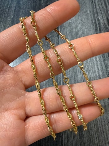 Textured Lozenge Link Diamond Station Chain: A 14K gold chain featuring infinity-style lozenge links and sparkling diamond stations.