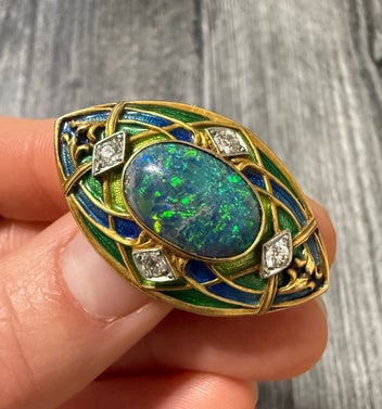 Art Nouveau Black Opal, Diamond, Enamel Brooch: A masterpiece brooch featuring a high-quality black opal and detailed floral enamel work.