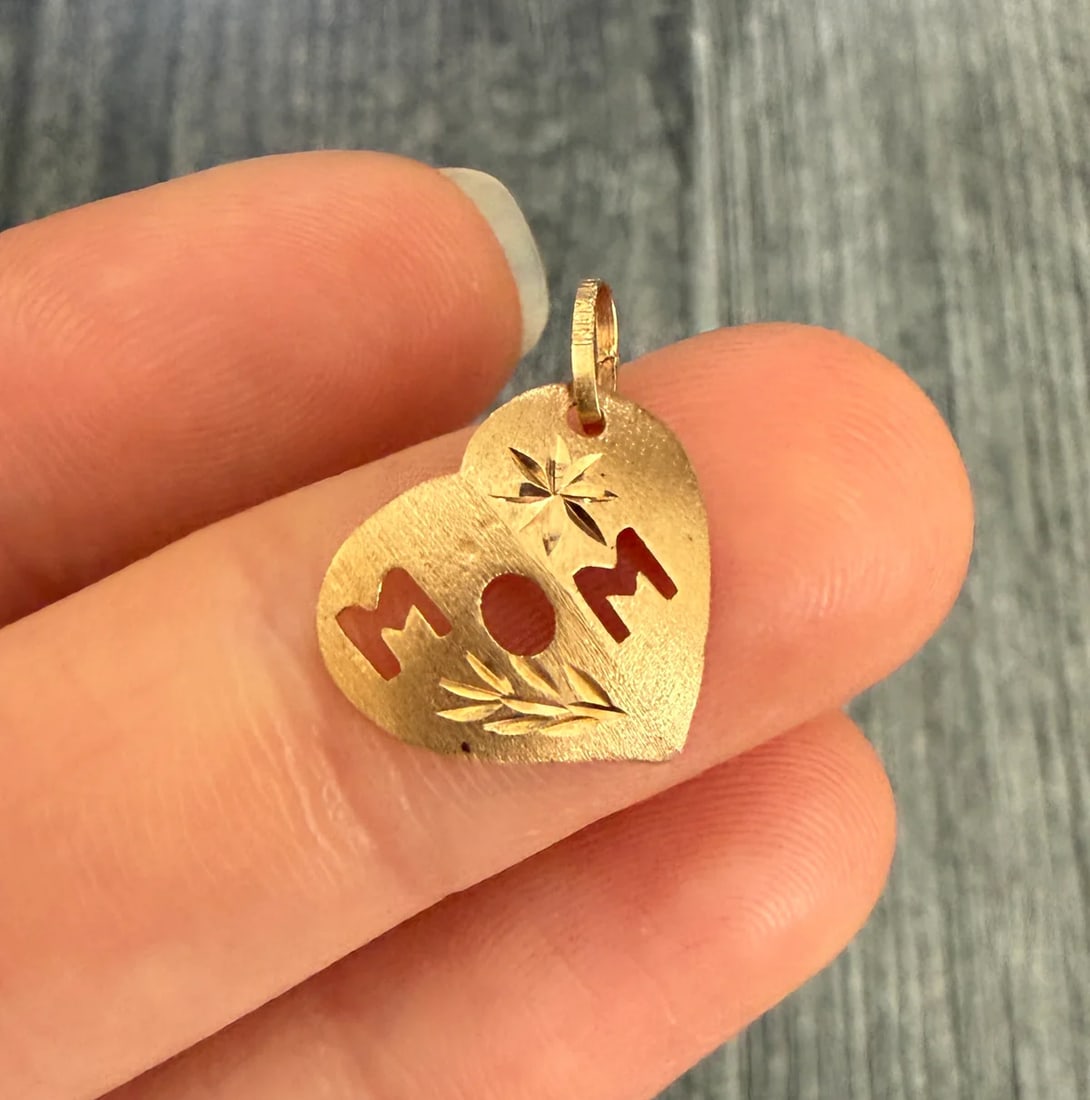 Vintage "MOM" Heart Charm In 14K Gold: Metal: 14K Yellow Gold Weight: 0.4 gramsMeasurements: 0.65 inches by 0.65 inches wideMarkings: "14K”