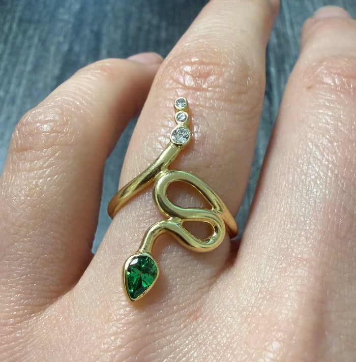 Tsavorite Garnet and Diamond Snake Ring: A serpentine 14K gold ring featuring a coiled snake body set with green tsavorite garnets and diamond accents.