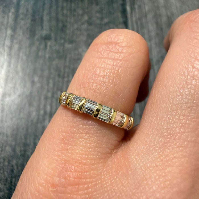 Channel Set Baguette Diamond Band in 18K Gold: A sophisticated 18K yellow gold band featuring a continuous row of channel-set baguette diamonds.