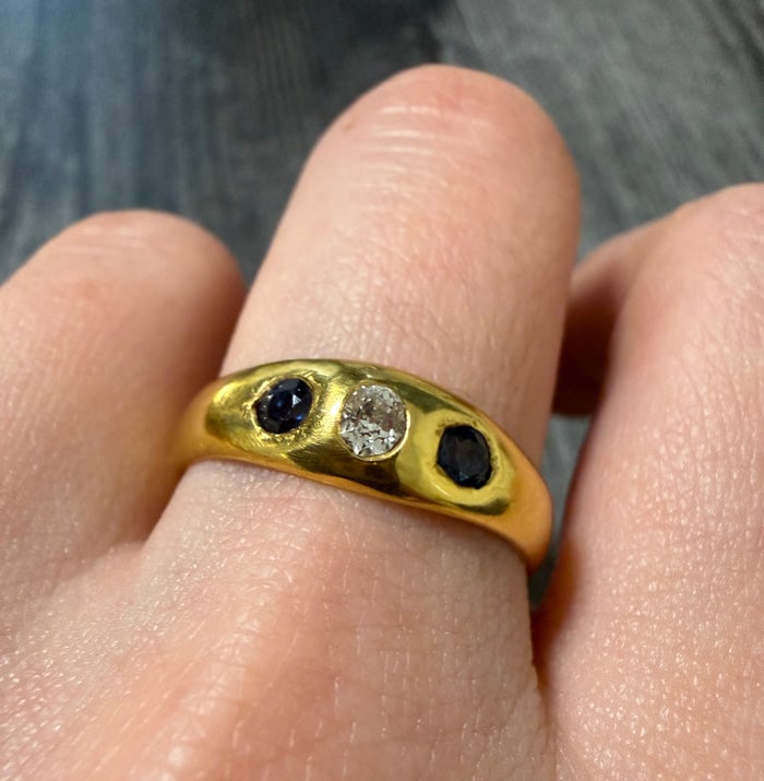 Sapphire and Diamond Flush Set Band in 18K Gold: A sleek 18K yellow gold band featuring alternating blue sapphires and diamonds flush-set into the metal.