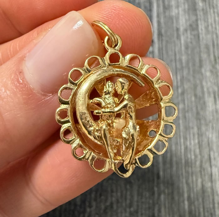 Kissing Couple Sitting on the Moon 14K Gold Charm: A romantic 14K gold charm depicting a silhouette of a couple kissing while seated on a crescent moon.