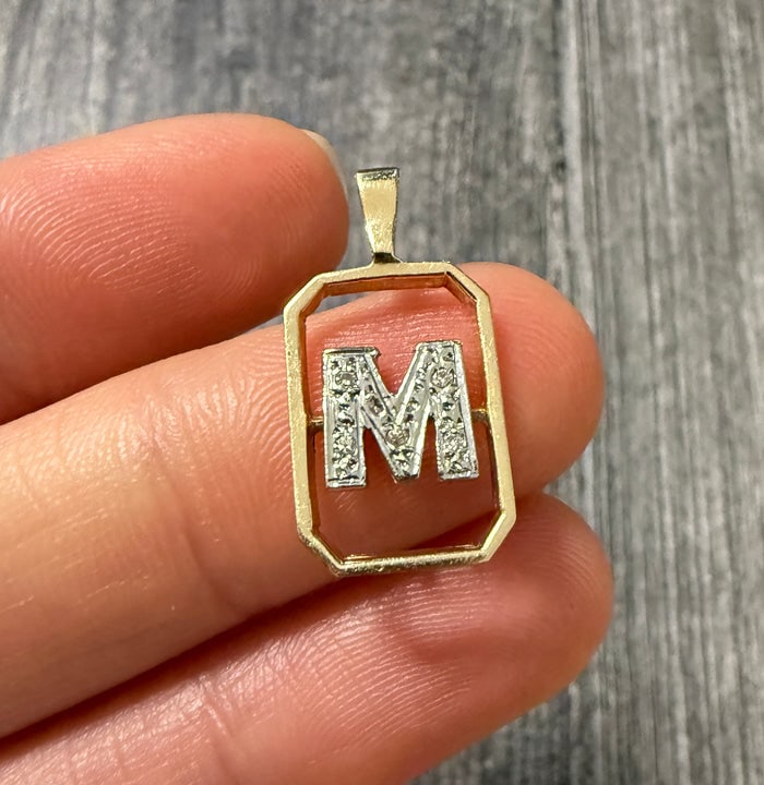 Diamond and 14K Gold Framed Initial "M" Charm: A 14K gold rectangular frame charm featuring a central letter "M" accented by shimmering diamonds.