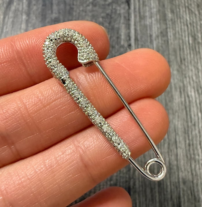 Diamond and 14K White Gold Safety Pin: Stylish safety pin design in 14K white gold accented with diamonds.
