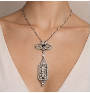 French Art Deco Platinum Diamond Watch Pendant on Diamond by the Yard Necklace: Platinum; French Art Deco watch pendant on a Diamond by the Yard chain.