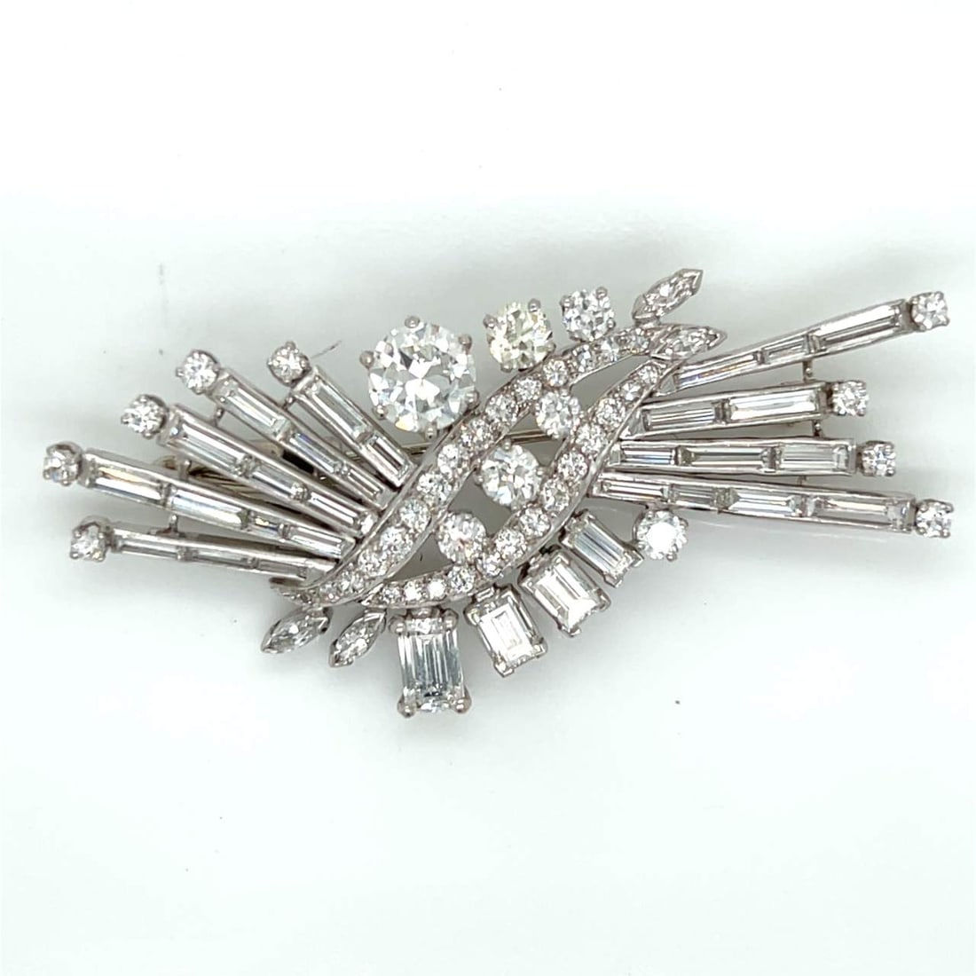 1950’s Platinum GIA Certified Diamond Brooch: 1950’s Platinum GIA Certified Diamond BroochWeighing 20.1 gramsSet with with a GIA Certified 1.55 Ct. DiamondH Color, VS2 ClarityAlong with 1 Emerald-cut Diamond weighing app. 1.00 Ct.3 Emerald-cut