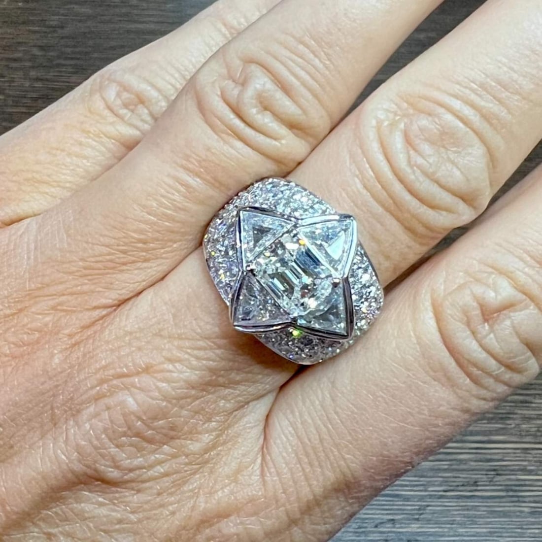 18K White Gold Diamond Cocktail Ring: 18K White Gold Diamond Cocktail RingWeighing 19.0 gramsSet with a 2.49 Ct. Emerald-cut Diamond in CenterJ Color, I1 ClarityAlong with 4 Trillion Diamonds weighing app. 2.20 Ct.And 54 Diamonds weighing