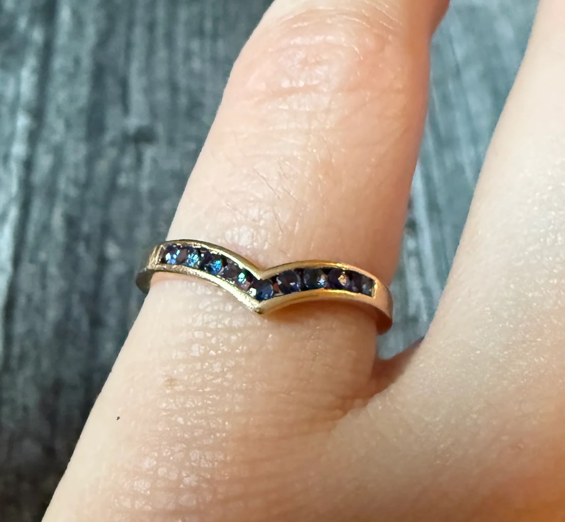Channel Set Sapphire "V" Band in 14K Gold (A): Metal: 14K Yellow Gold Weight: 1.5 gramsSapphire: Approximately 0.22 caratsRing Size: 6 (resizable)Markings: "14K"Condition: In good vintage condition with some minor surface wearFollow us on
