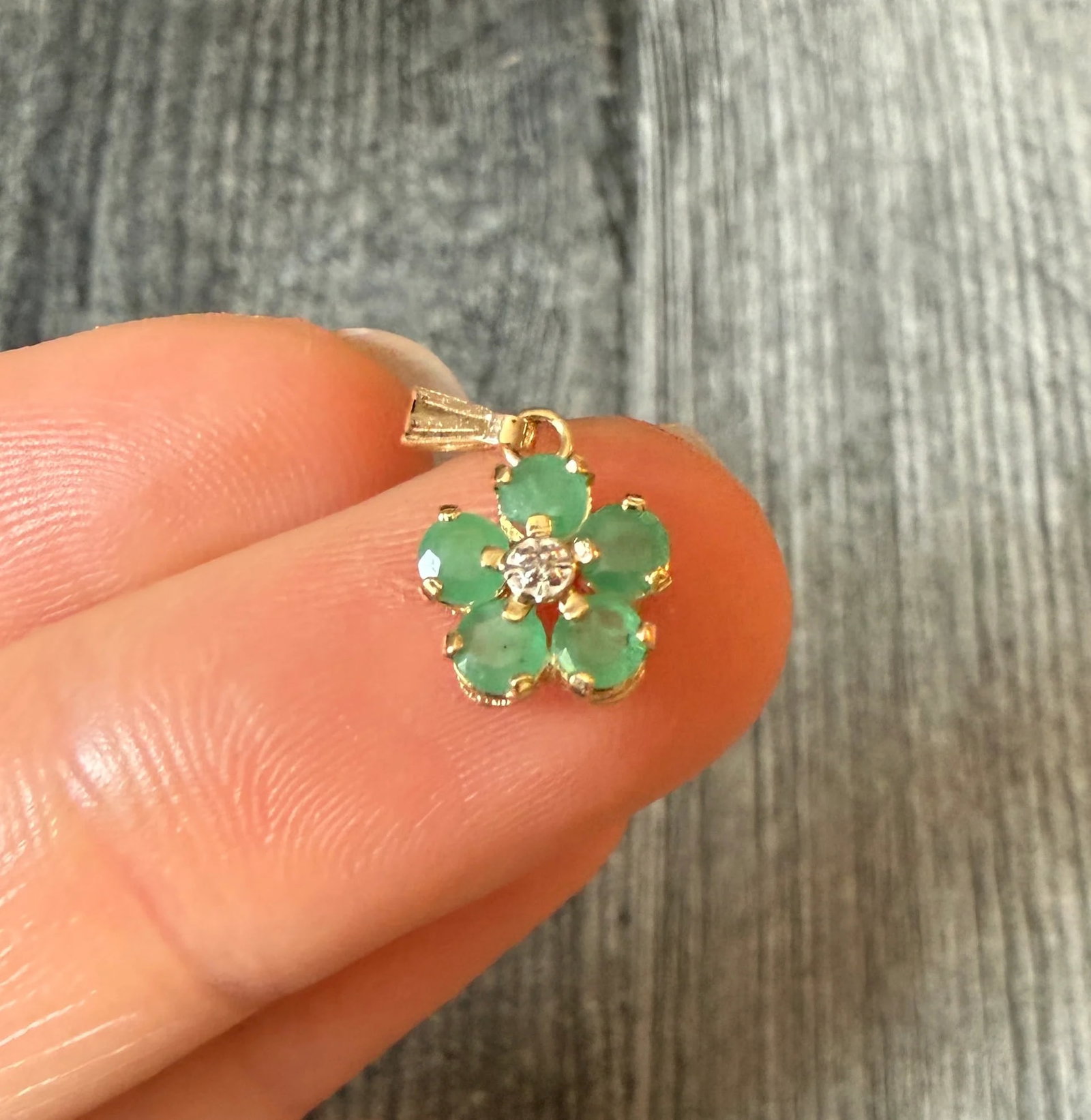 Mini Emerald and Diamond Flower Charm in 14K Gold: Metal: 14K Yellow GoldWeight: 0.6 gramsMeasurements: 0.3 inches long by 0.3 inches wideMarkings: "14K"Condition: In good condition with some minor surface wear Follow us on Instagram