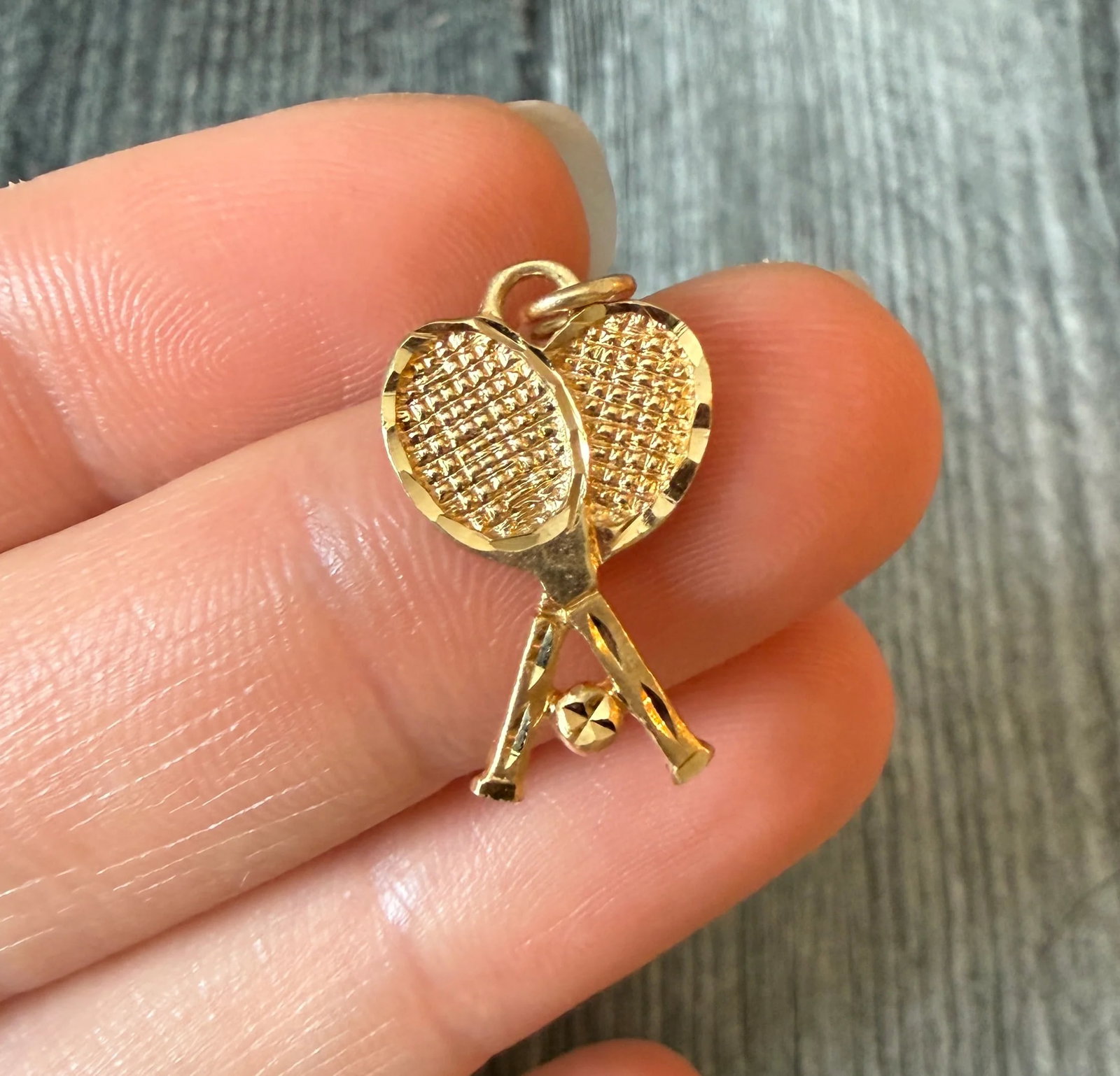 Tennis Racket and Ball Charm in 14K Gold: Metal: 14K Yellow GoldWeight: 1.9 gramsMeasurement: 0.75 inches long by 0.55 inches wide Markings: "14K"Condition: In good condition with some minor surface wearFollow us on Instagram