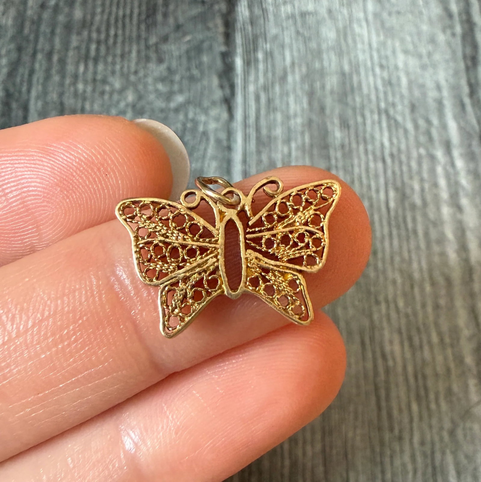 Vintage Filigree Butterfly Charm in 14K Gold: Metal: 14K Yellow GoldWeight: 1.6 gramsMeasurement: 0.55 inches long by 0.8 inches wideCondition: in good condition with some minor surface wearFollow us on Instagram @alphaomegajewelry for the latest