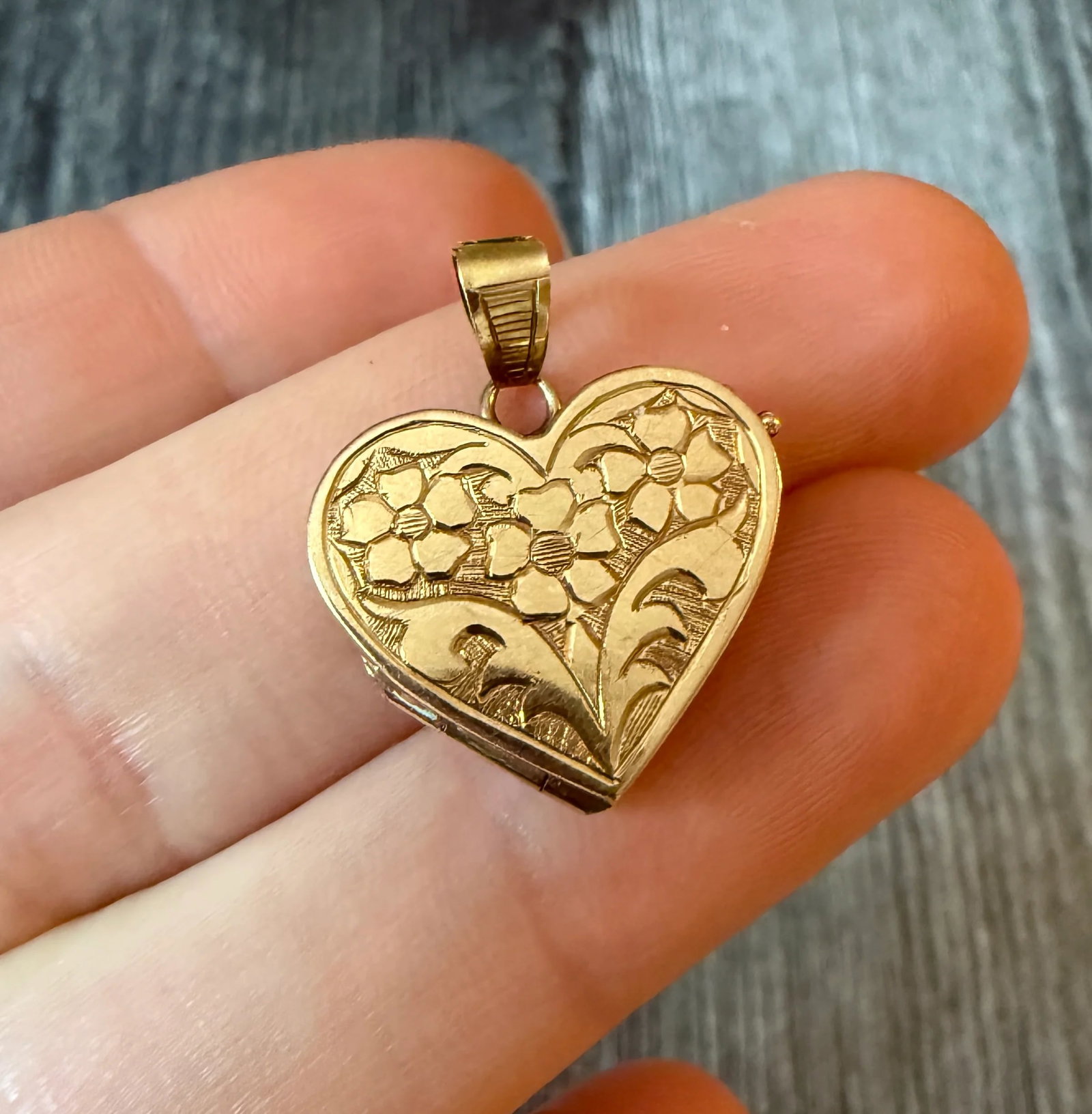 Chased Floral Motif Heart Locket in 14K Gold (S): Metal: 14K Yellow GoldWeight: 1.9 gramsMeasurements: 0.7 inches long by 0.75 inches wideMarkings: "585"Condition: In good condition with some minor surface wear Follow us on Instagram @alphaomegajewel