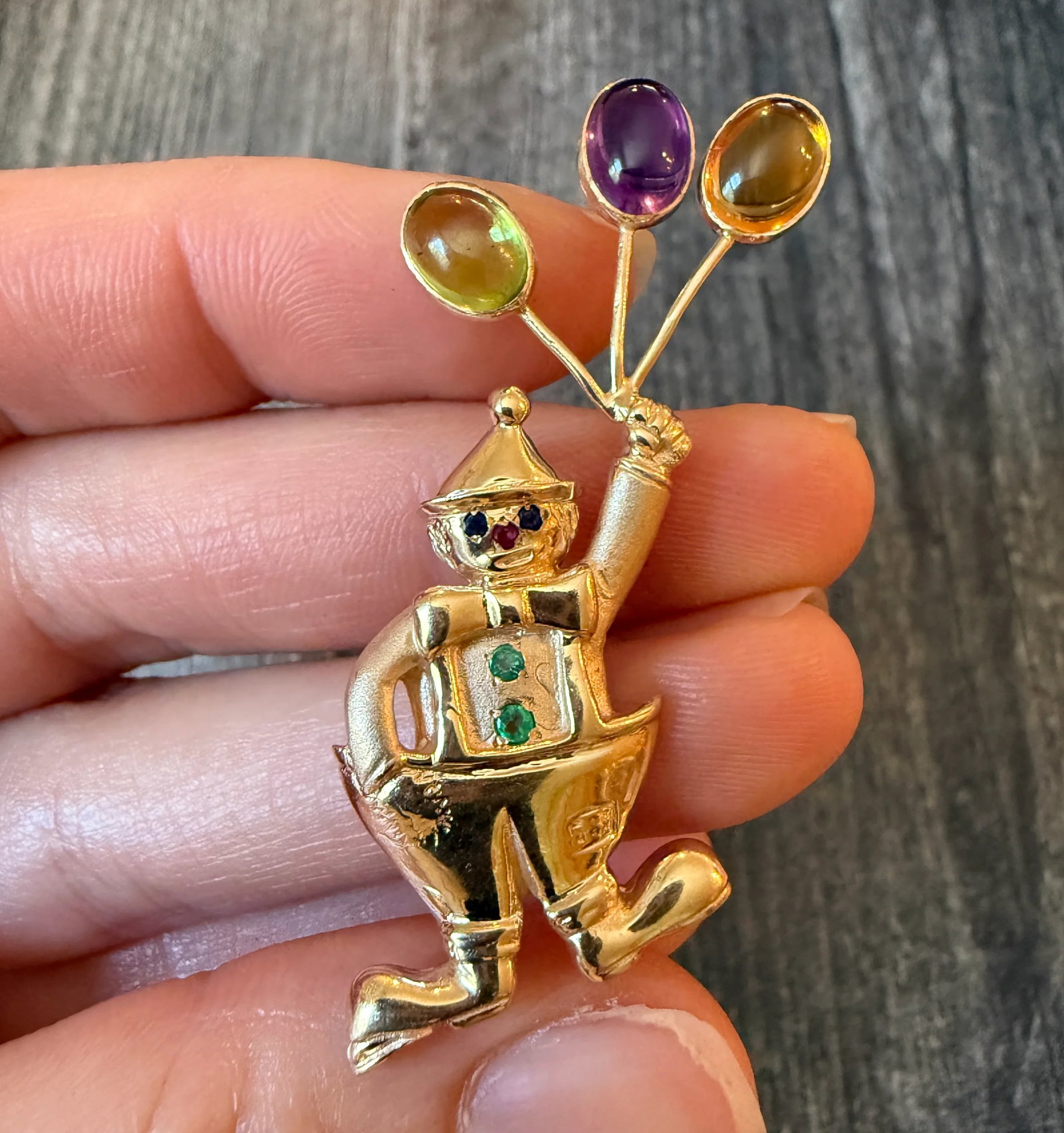 Playful Brooch of a Clown with Cabochon Gemstone Balloons (S): Metal: 14K Yellow Gold Weight: 9 gramsMeasurements: 2.25 inches long by 0.9 inches wideCondition: In very good condition with some minor surface wear Follow us on Instagram @alphaomegajewelry for the 