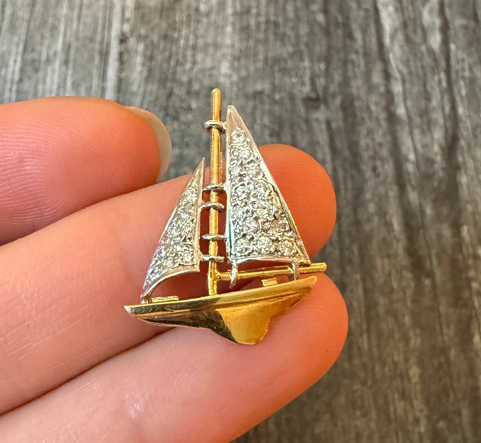 Diamond and 18K Gold Sailboat Charm: Metal: 18K Yellow & White Gold Weight: 3 gramsDiamonds: Approximately 0.68 caratsMeasurements: 1.1 inches long by 0.8 inches wideMarkings: "18K"Condition: In very good condition with some minor