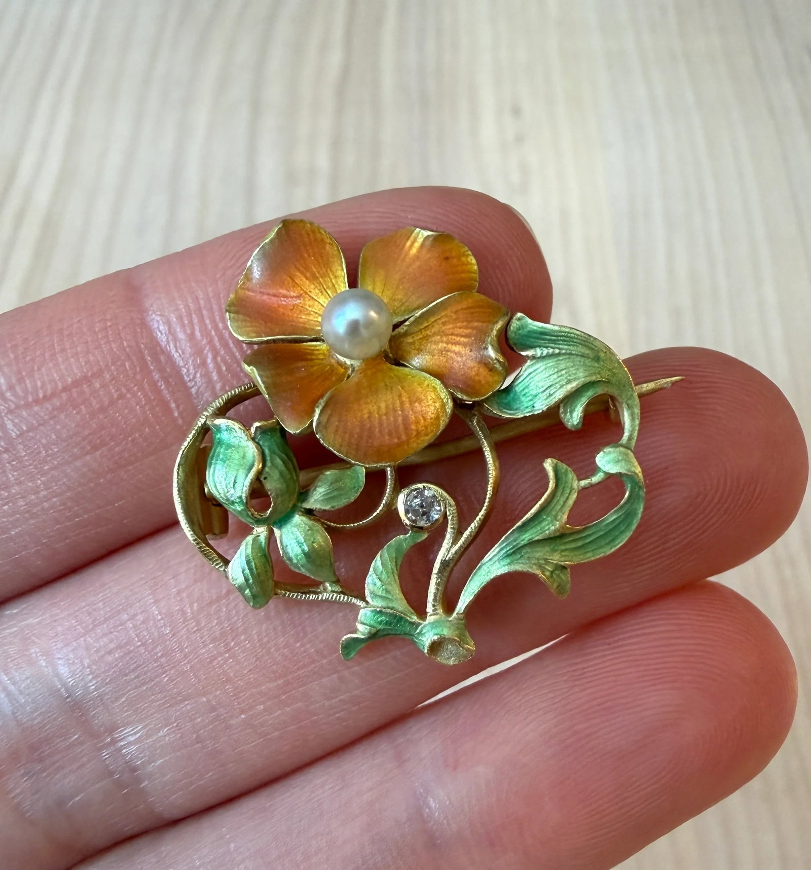 Art Nouveau Orange Enameled Flower Pin in 18K Gold: Metal: 18K Yellow GoldWeight: 6.4 gramsDiamond: Approx 0.05 caratsMeasurements: 1.1" long by 1.1" wideMarkings: "18K"Condition: In very good antique condition with some minor surface wear consistent