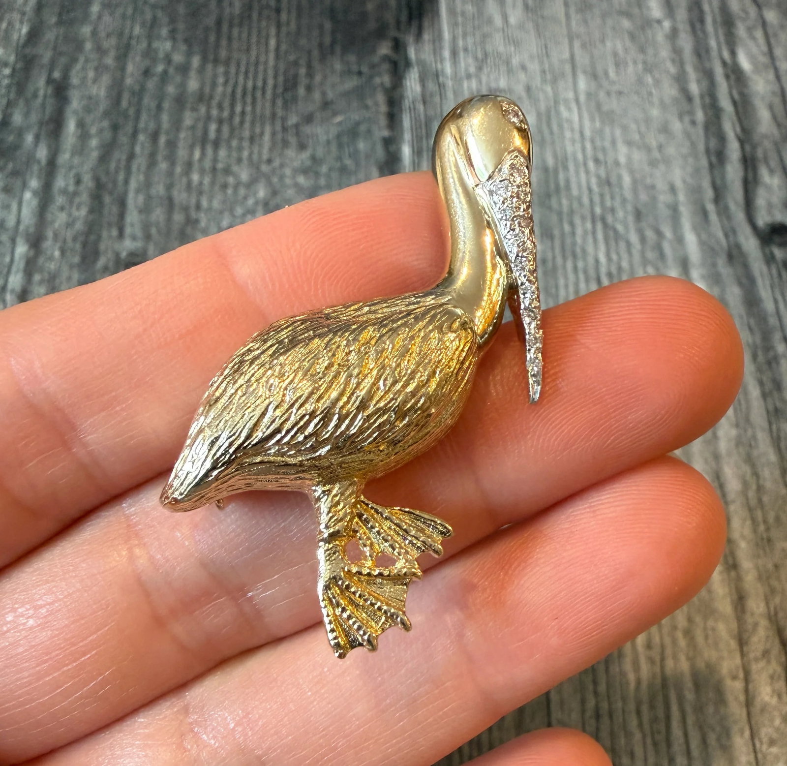 Large Diamond Pelican Brooch in 14K Gold (S): Metal: 14K Yellow Gold Weight: 10.9 gramsDiamonds: Approximately 0.10 caratsMeasurement: 1.75 inches long by 1.3 inches wide Markings: "14K"Condition: In good condition with some minor surface wearFol