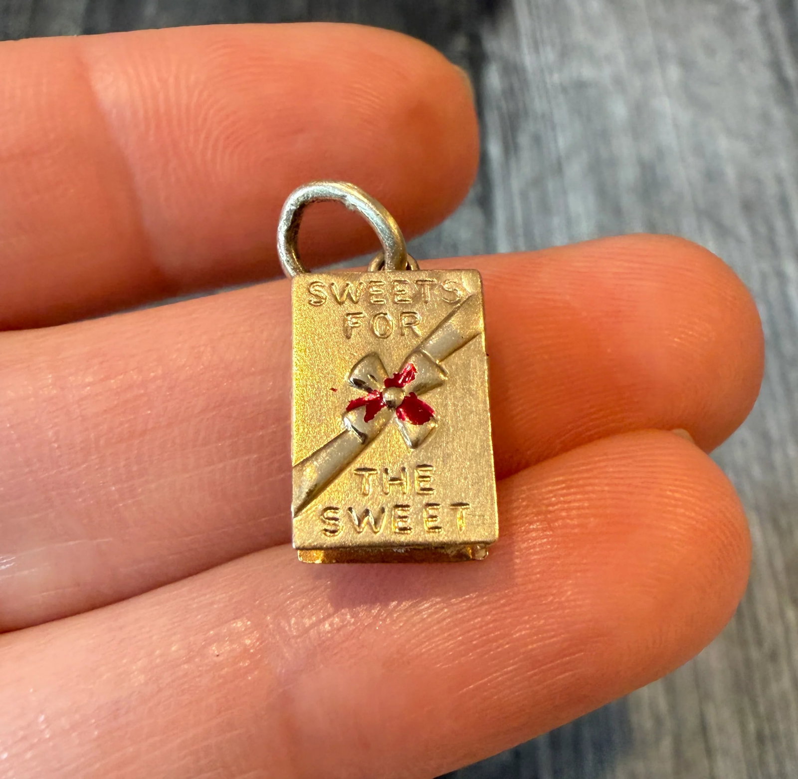 "Sweets For The Sweet" Box of Chocolates Charm in 14K Gold: Metal: 14K Yellow Gold Weight: 2.3 gramsMeasurements: 0.5 inches long by 0.3 inches wideMarkings: "14K" "Sweets for the Sweet"Condition: In good condition with enamel loss and some minor surface wear 