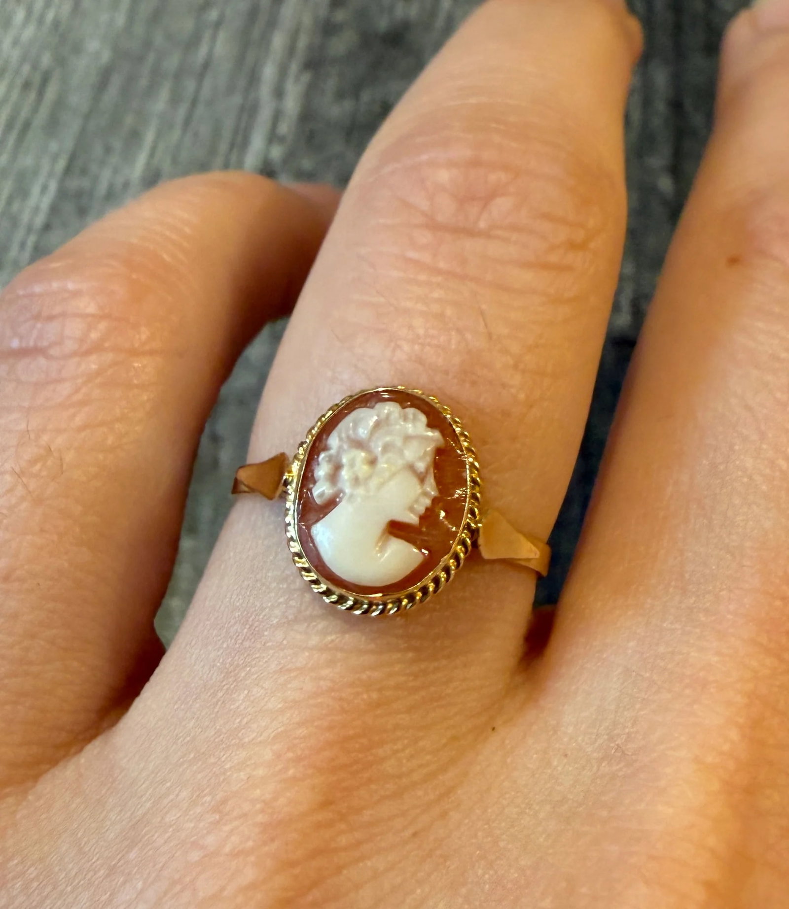 Small Shell Cameo Ring of a Woman's Profile in 10K Gold: Metal: 10K Yellow Gold Weight: 1.7 gramsRing Size: 7.25 (resizable)Condition: In very good condition with some minor surface wear Follow us on Instagram @alphaomegajewelry for the latest updates from 