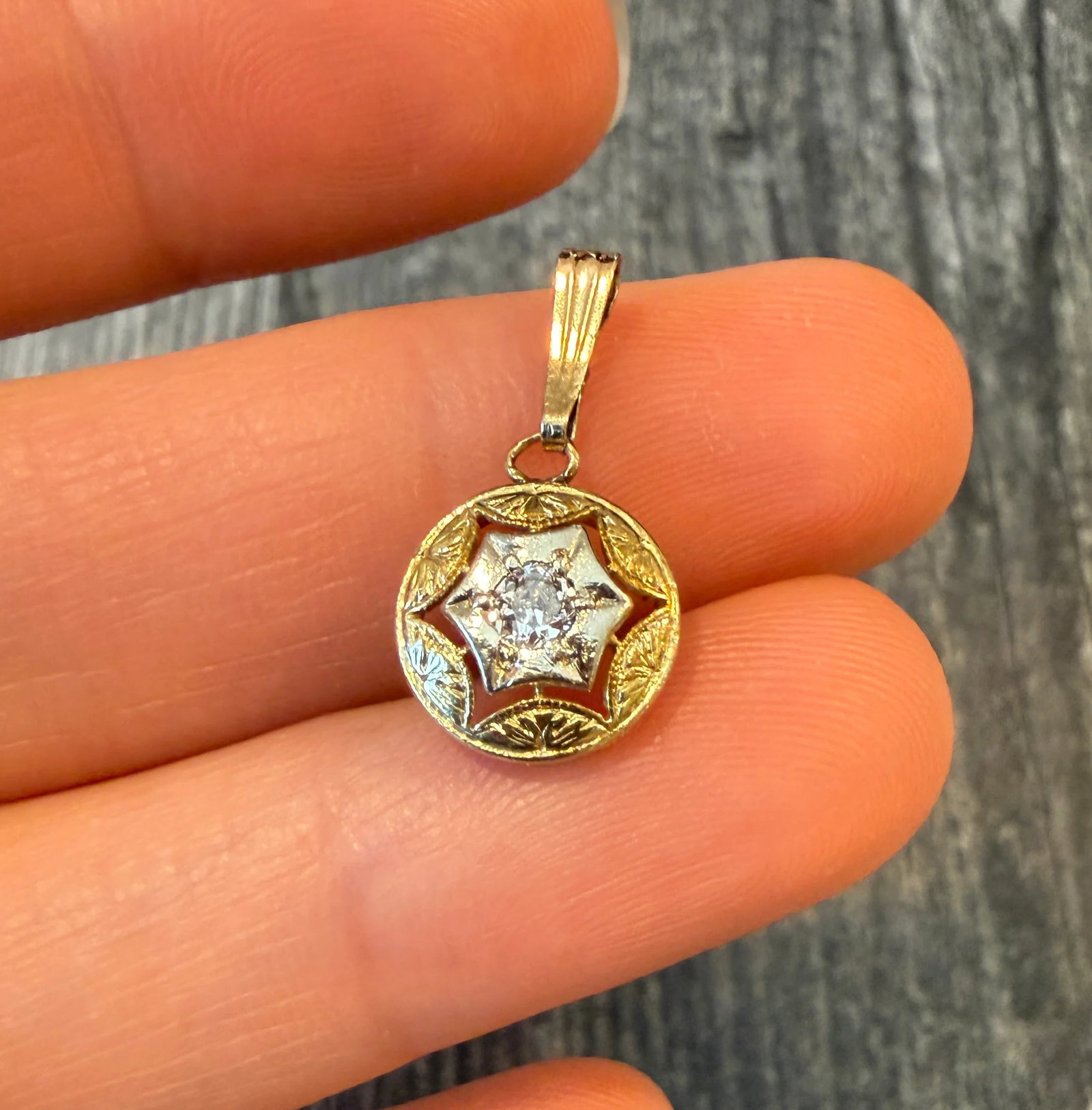 Art Deco Diamond and 14K Gold Round Star Charm: Metal: 14K Yellow and White Gold Weight: 1.2 gramsDiamond: Approximately 0.12 caratsMeasurement: 0.45 inch diameter Markings: "14K”Condition: In good condition with some minor surface wear consi