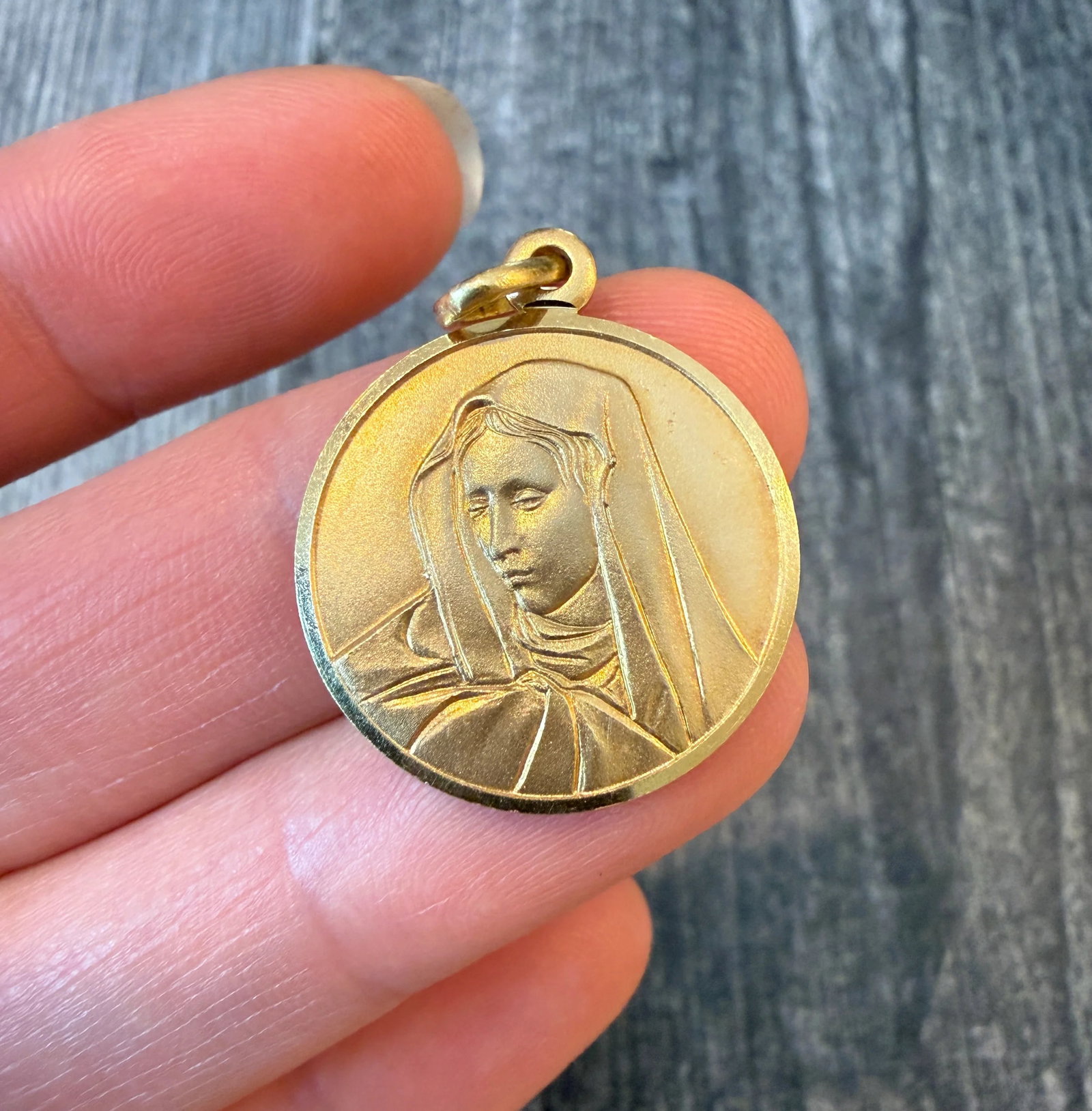 Virgin Mary Medal Charm in 14K Gold: Metal: 14K Yellow Gold Weight: 4.8 gramsMeasurements: 0.9 inch diameterMarkings: "KT14 ITALY"Condition: In very good condition with some minor surface wear Follow us on Instagram @alphaomegajewelry fo