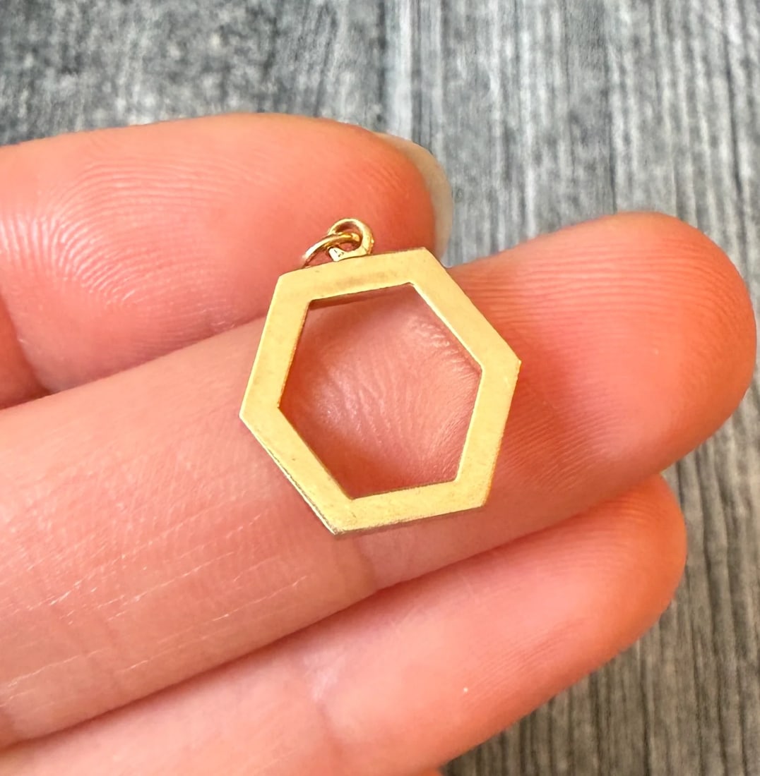 Open Hexagon Charm in 14K Gold: Metal: 14K Yellow Gold (acid tested)Weight: 1.8 gramsMeasurements: 0.55 inches long by 0.55 inches wide Markings: NoneCondition: In very good condition with some minor surface wear Follow us on Instag