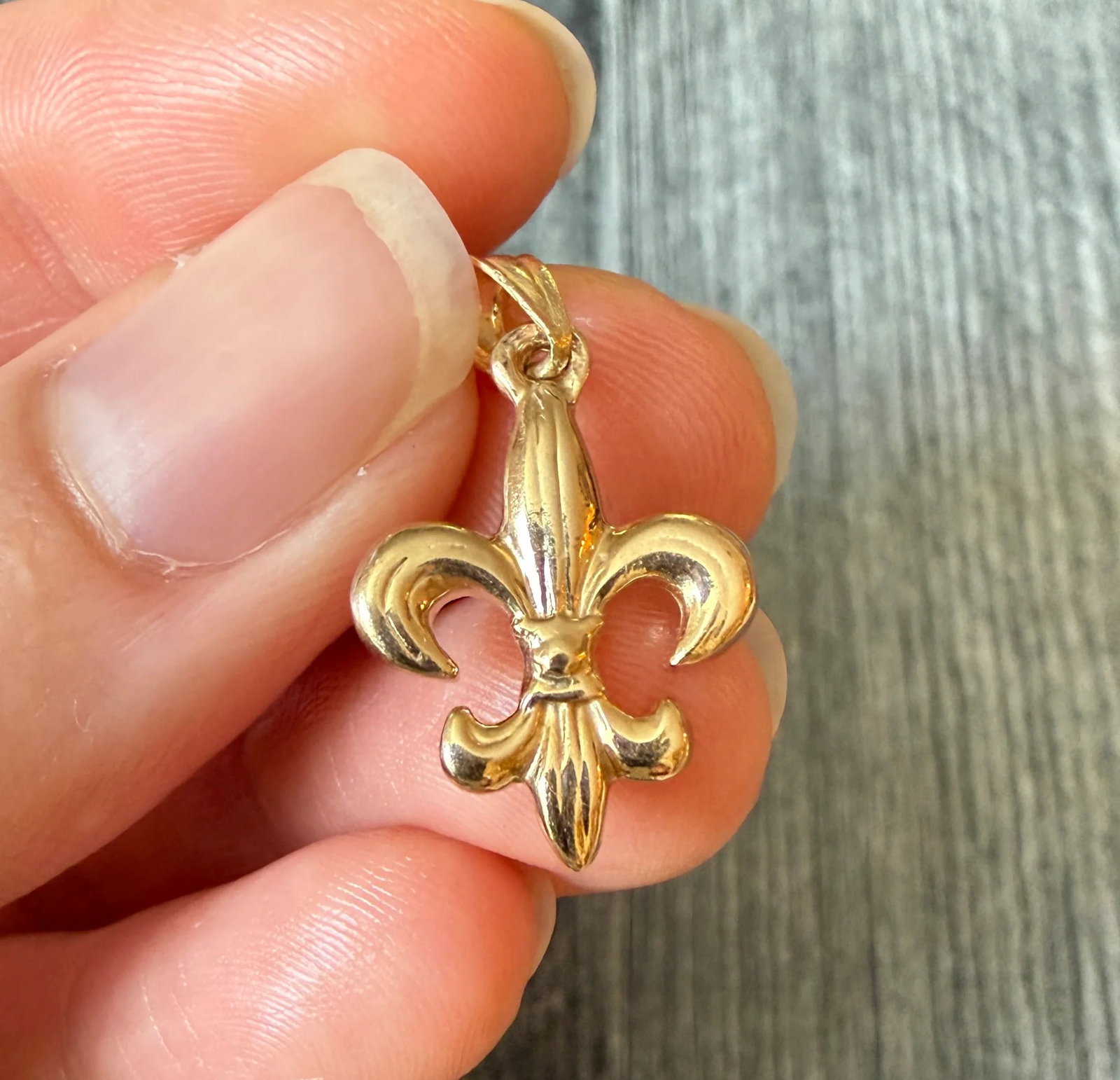 Fleur De Lis Charm in 14K Gold: Metal: 14K Yellow GoldWeight: 3.2 gramsMeasurements: 0.75 inches long by 0.65 inches wideMarkings: "14K"Condition: In very good condition with some minor surface wear Follow us on Instagram @alphaomeg