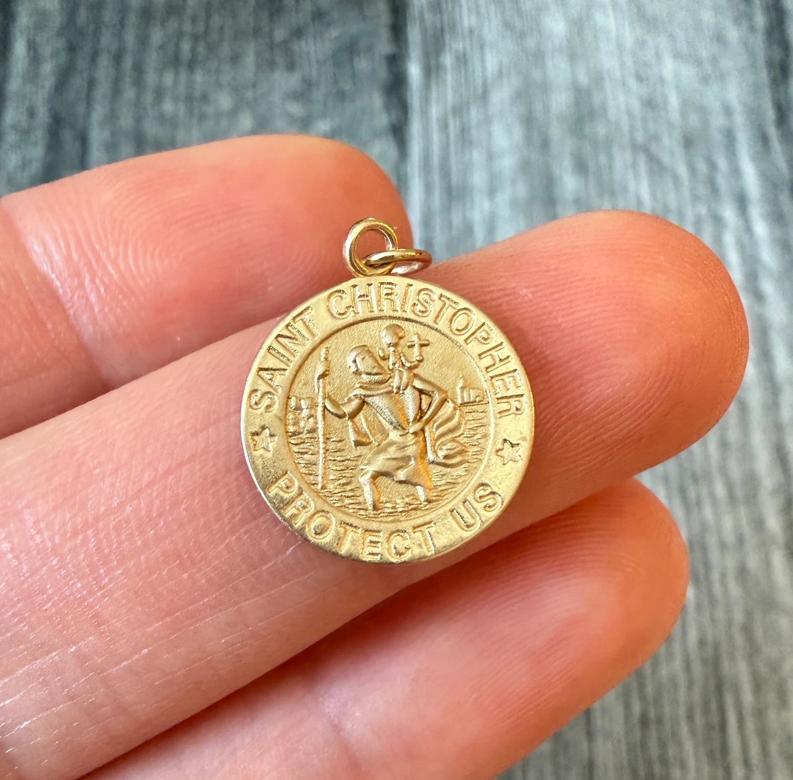 Small St. Christopher Traveler Charm in 14K Gold: Metal: 14K Yellow Gold Weight: 1 gramMeasurements: 0.55 inch diameter Condition: In very good condition with some minor surface wear Follow us on Instagram @alphaomegajewelry for the latest updates fr