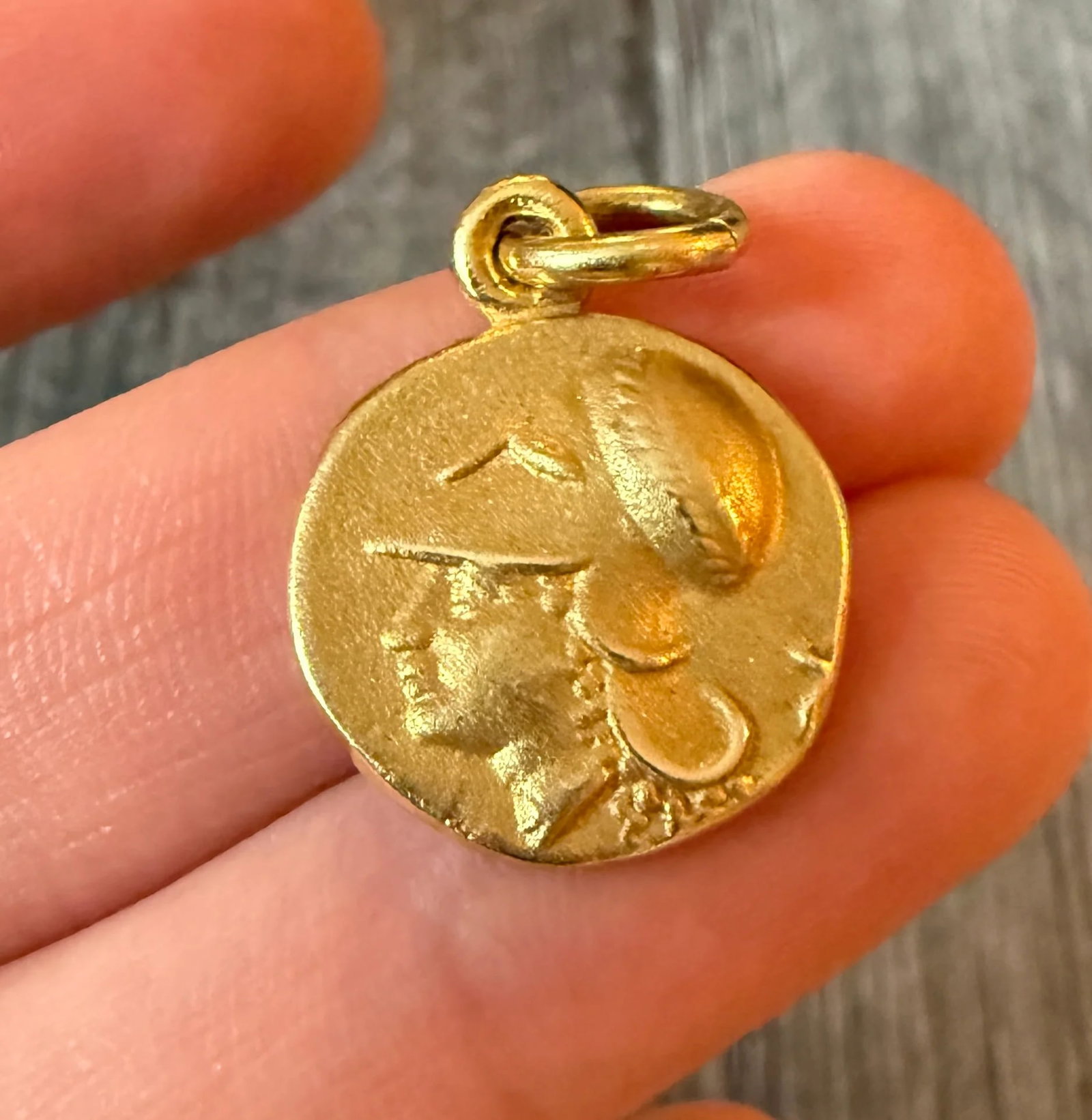 Athena & Pegasus Greek Coin Charm in 18K Gold: Metal: 18K Yellow Gold Weight: 9.2 gramsMeasurements: 0.75 inch diameter Markings: "750"Condition: In good condition with some minor surface wearFollow us on Instagram @alphaomegajewelry for the lates
