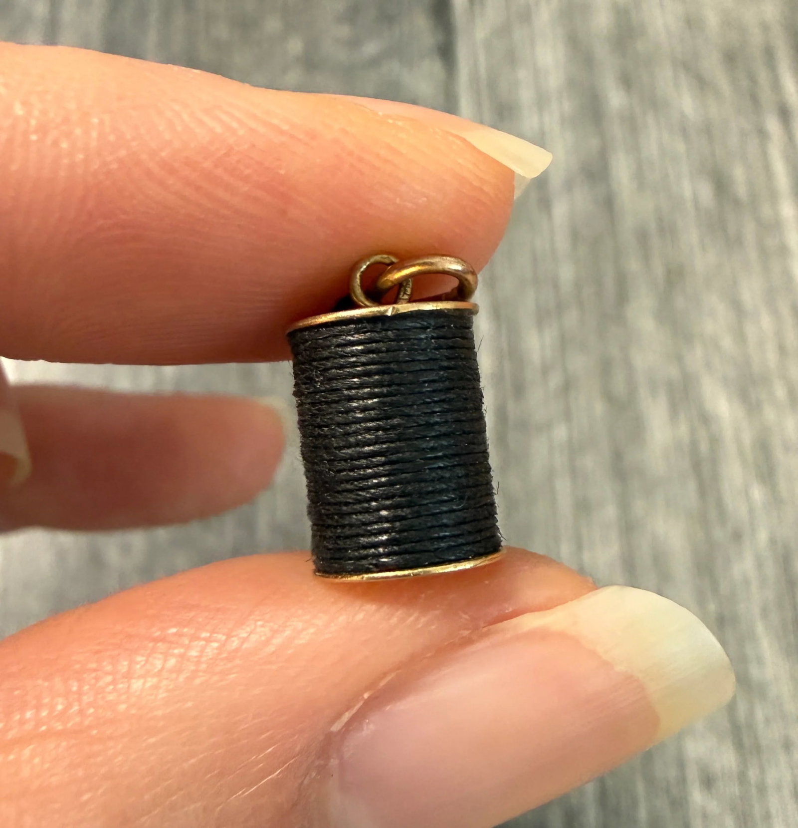 Spool of Thread In 14K Yellow Gold Charm: Metal: 14K Yellow Gold Weight: 1.7 gramsMeasurements: 0.5 inches long by 0.3 inches wideMarkings: "14KT"Condition: In good vintage condition with some minor surface wearFollow us on Instagram @alphaom