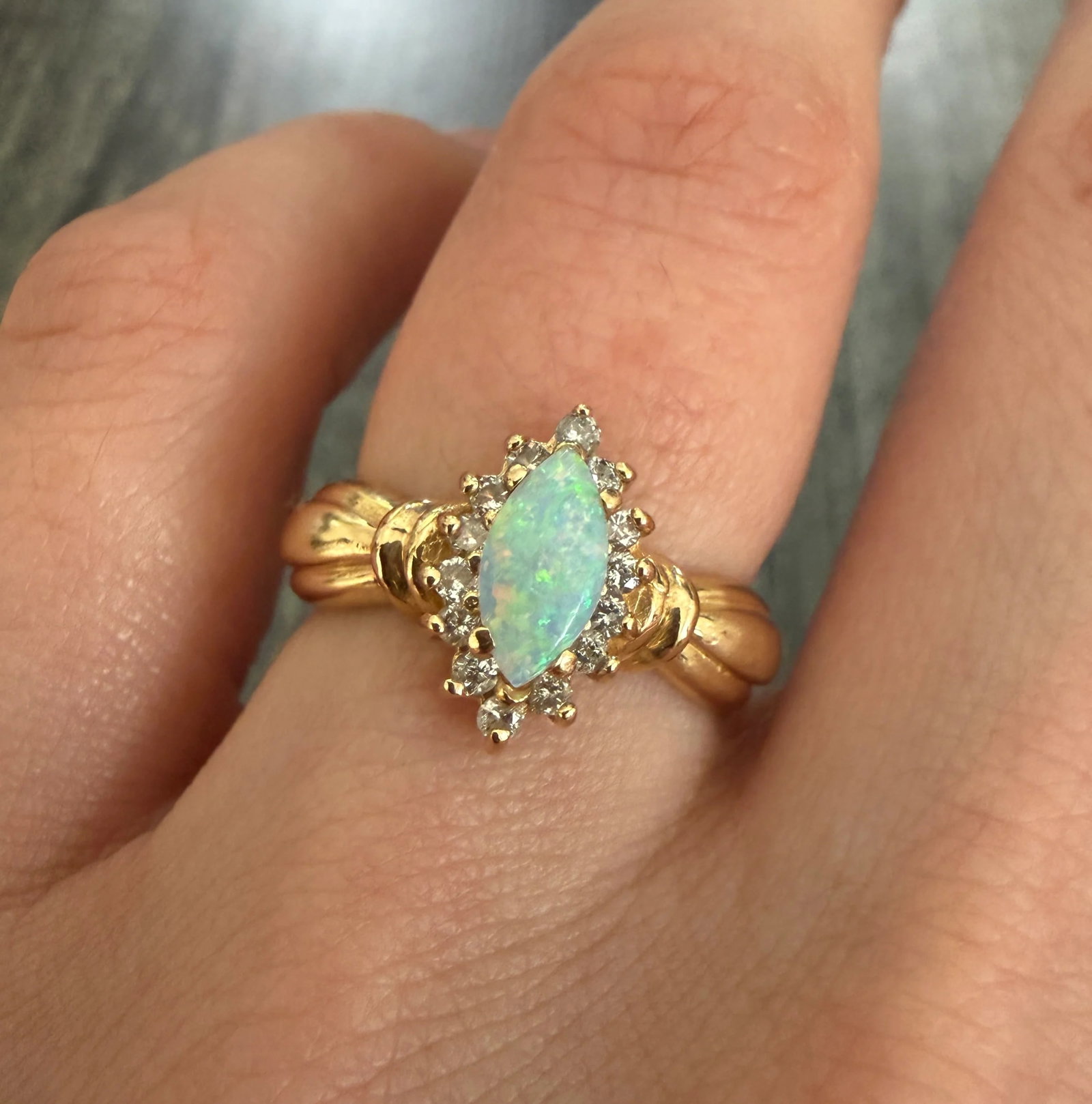 Marquise Opal and Diamond Ring in 14K Gold: Metal: 14K Yellow Gold Weight: 4.6 gramsRing Size: 6.25 (resizable)Markings: "14K"Condition: In good condition with some minor surface wearFollow us on Instagram @alphaomegajewelry for the latest upda
