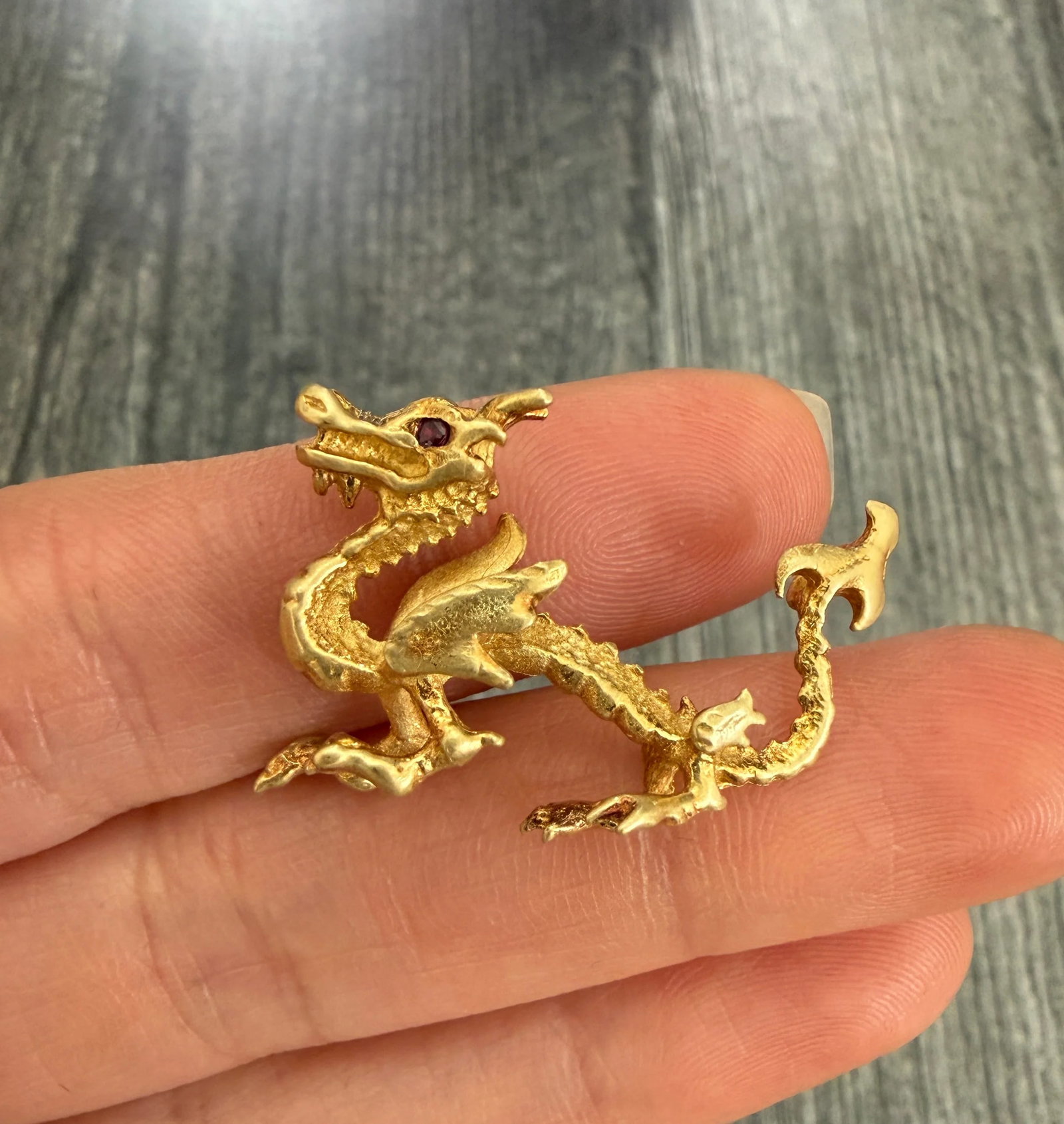 Handmade 18K Gold Dragon Pendant: Metal: 18K Yellow Gold (acid tested)Weight: 7.4 gramsMeasurements: 1 inch long by 1.25 inches wideCondition: In good vintage condition with some surface wear. There are two loops soldered in the back 
