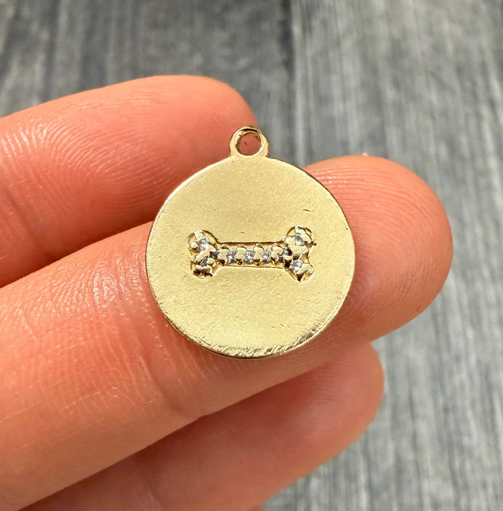Diamond and 14K Gold Dog Bone Disc Charm: Metal: 14K Yellow Gold Weight: 2.6 gramsMeasurements: 0.55 inches diameter Condition: Some small dings and wear throughout the charm. A bale can be added if requested prior to shipping.Follow us on In