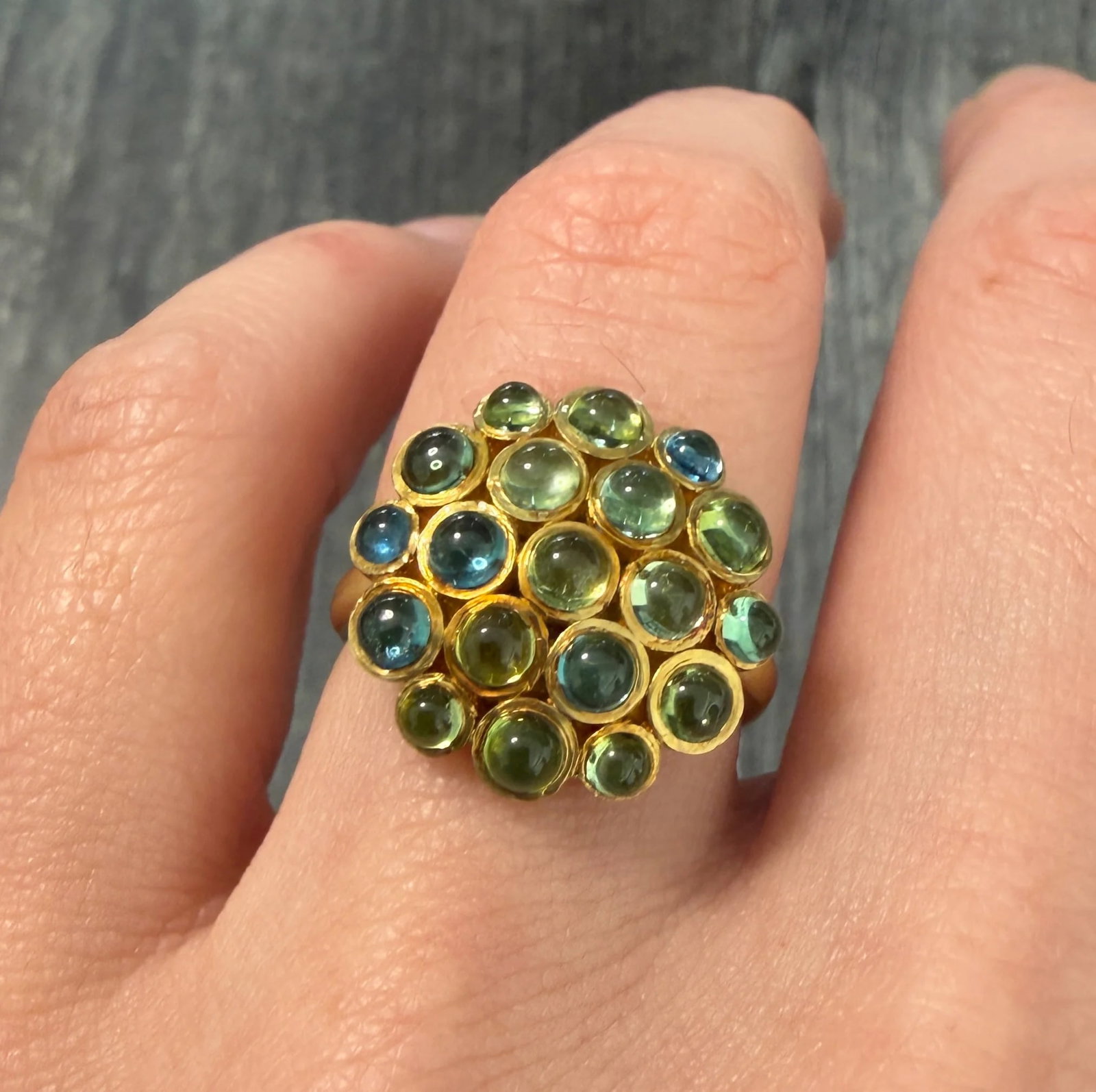 Cabochon Peridot and Blue Topaz Hydrangea Cluster Ring in 18K Gold: Metal: 18K Yellow Gold Weight: 7 gramsRing Size: 6.75 (resizable)Markings: "18K"Condition: In very good condition with some minor surface wearFollow us on Instagram @alphaomegajewelry for the latest u