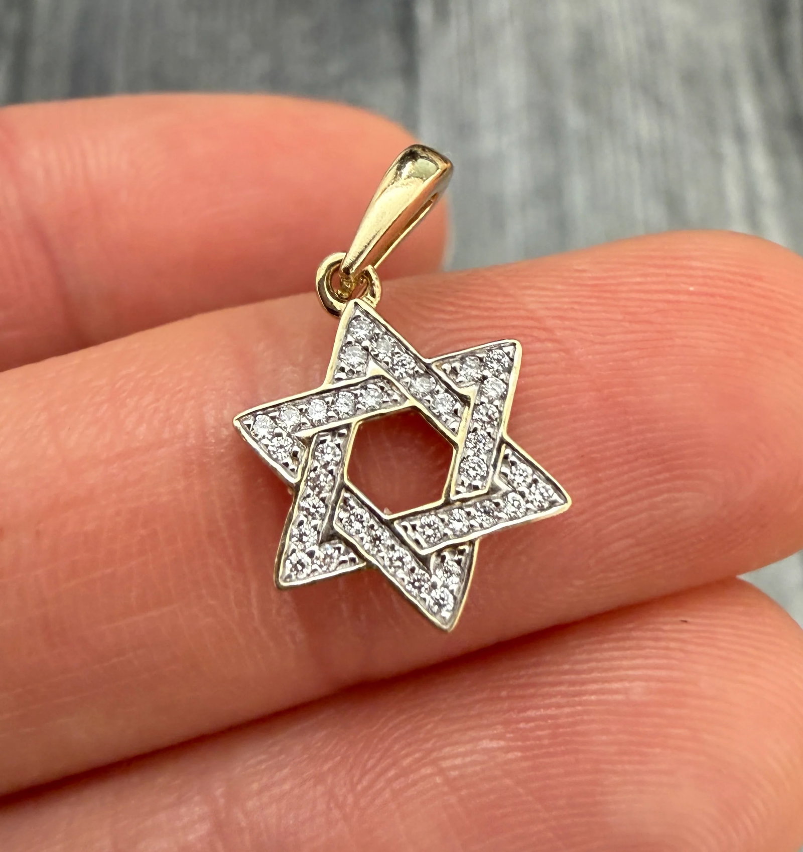 Diamond Star of David Charm in 14K Gold: Metal: 14K Yellow & White Gold Weight: 1 gramDiamonds: Approximately 0.18 caratsMeasurements: 0.5 inches long by 0.45 inches wideMarkings: 14KCondition: In very good condition with some minor surface 